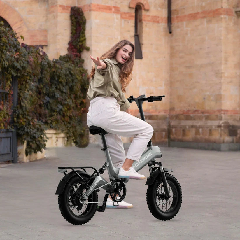 Woman riding a small electric bike in an urban setting
