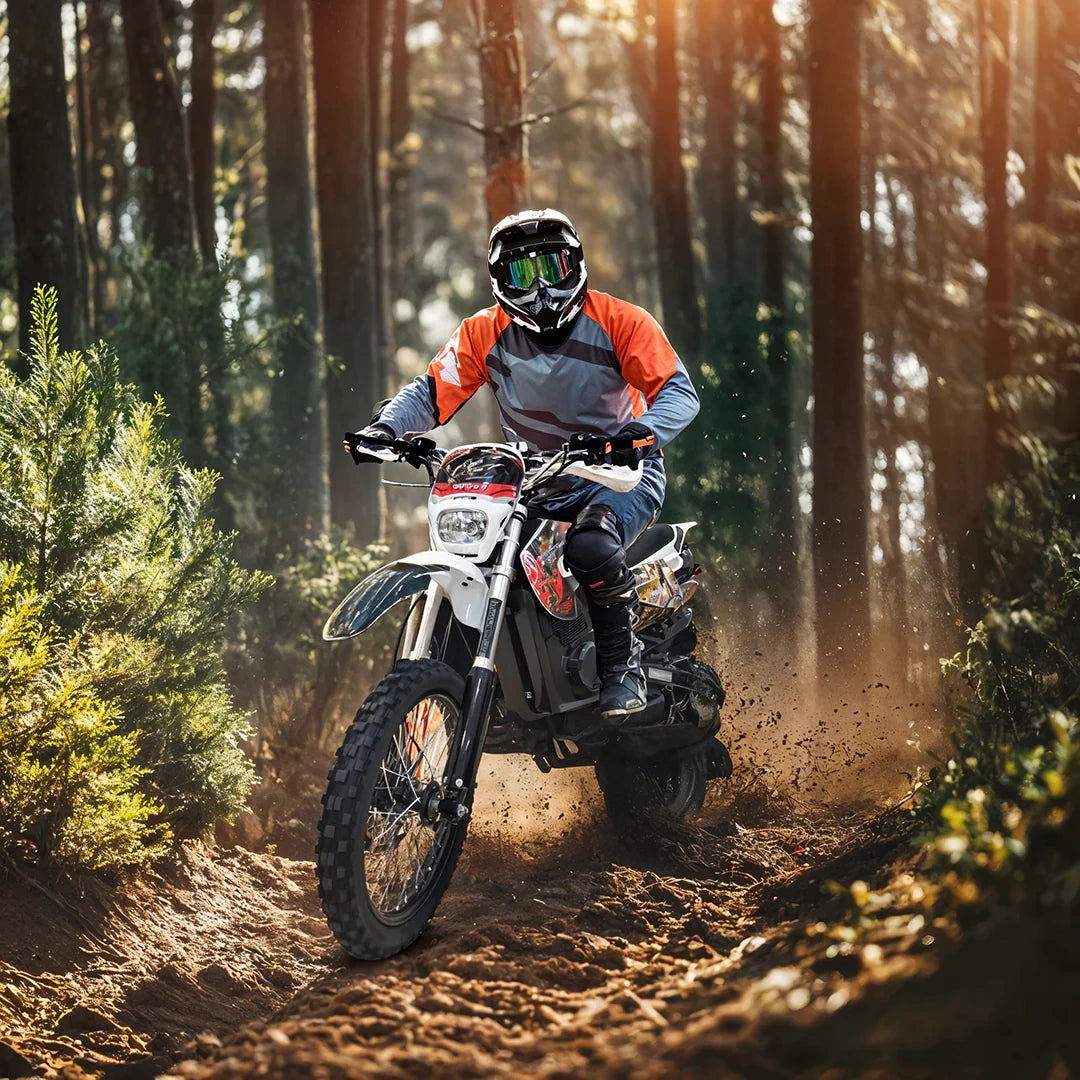 Person riding a dirt bike through a forest trail