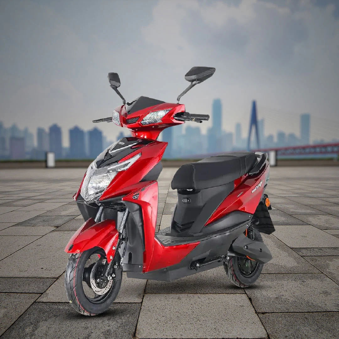 Red scooter on a paved area with a cityscape in the background