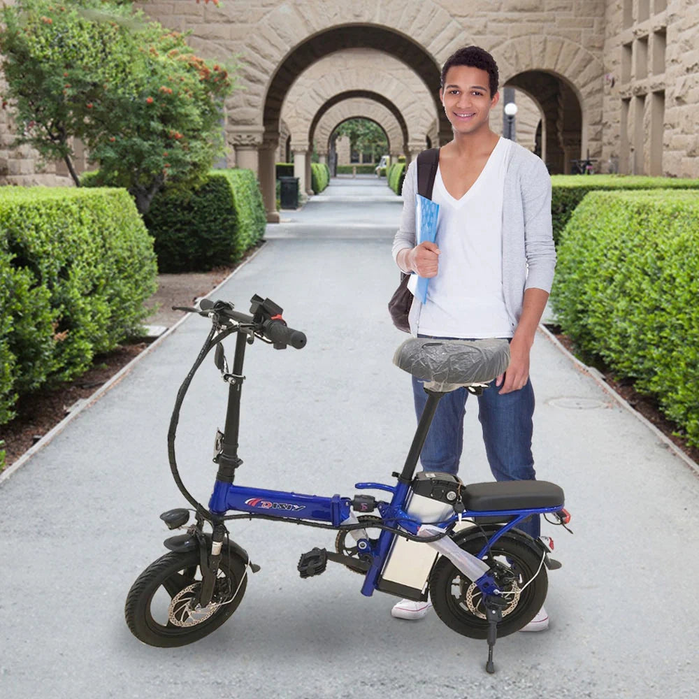 Person holding a blue electric scooter on a path with greenery and a building in the background