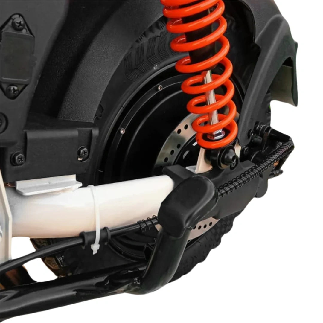 Close-up of a motorcycle suspension system with an orange spring on a white background
