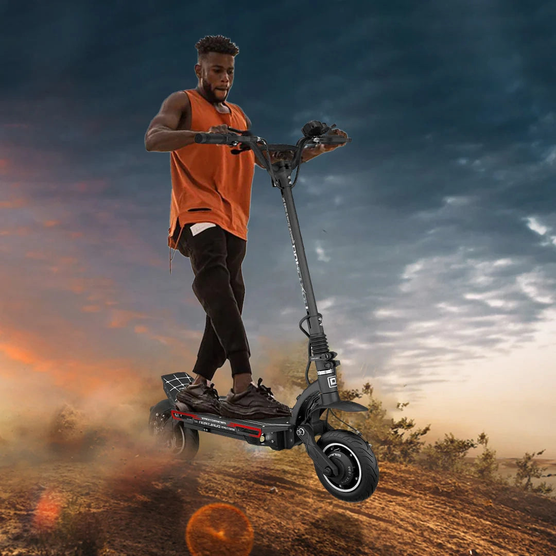 Person riding an electric scooter against a dramatic sky with clouds and sunset hues.