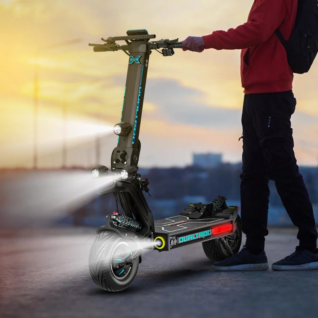 Person holding a folded electric scooter with a cityscape background