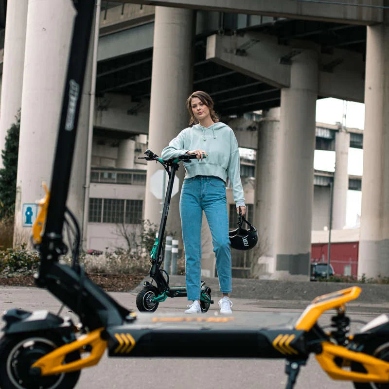 Woman standing with an electric scooter in an urban setting