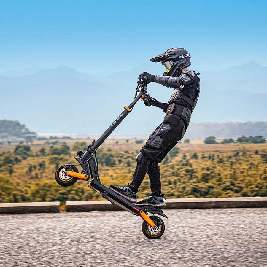 Person riding a scooter with a helmet and protective gear on a road with a scenic background