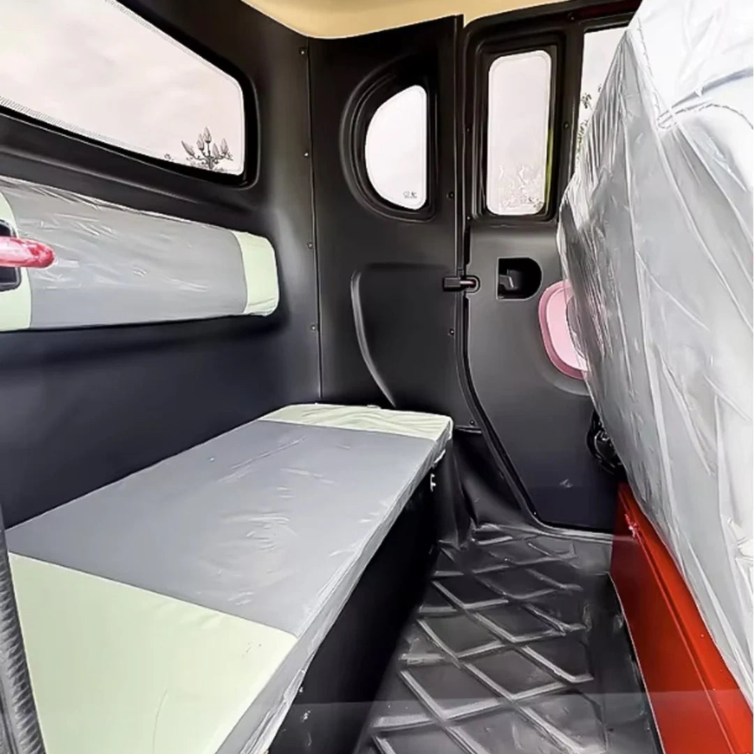 Interior of a van with a bed setup and plastic covering