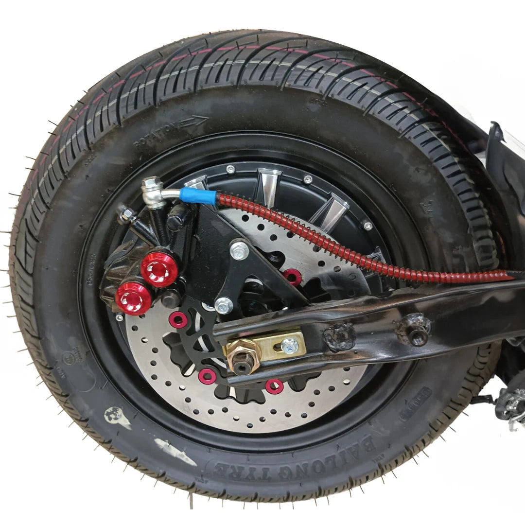 Close-up of a motorcycle tire and suspension system on a white background