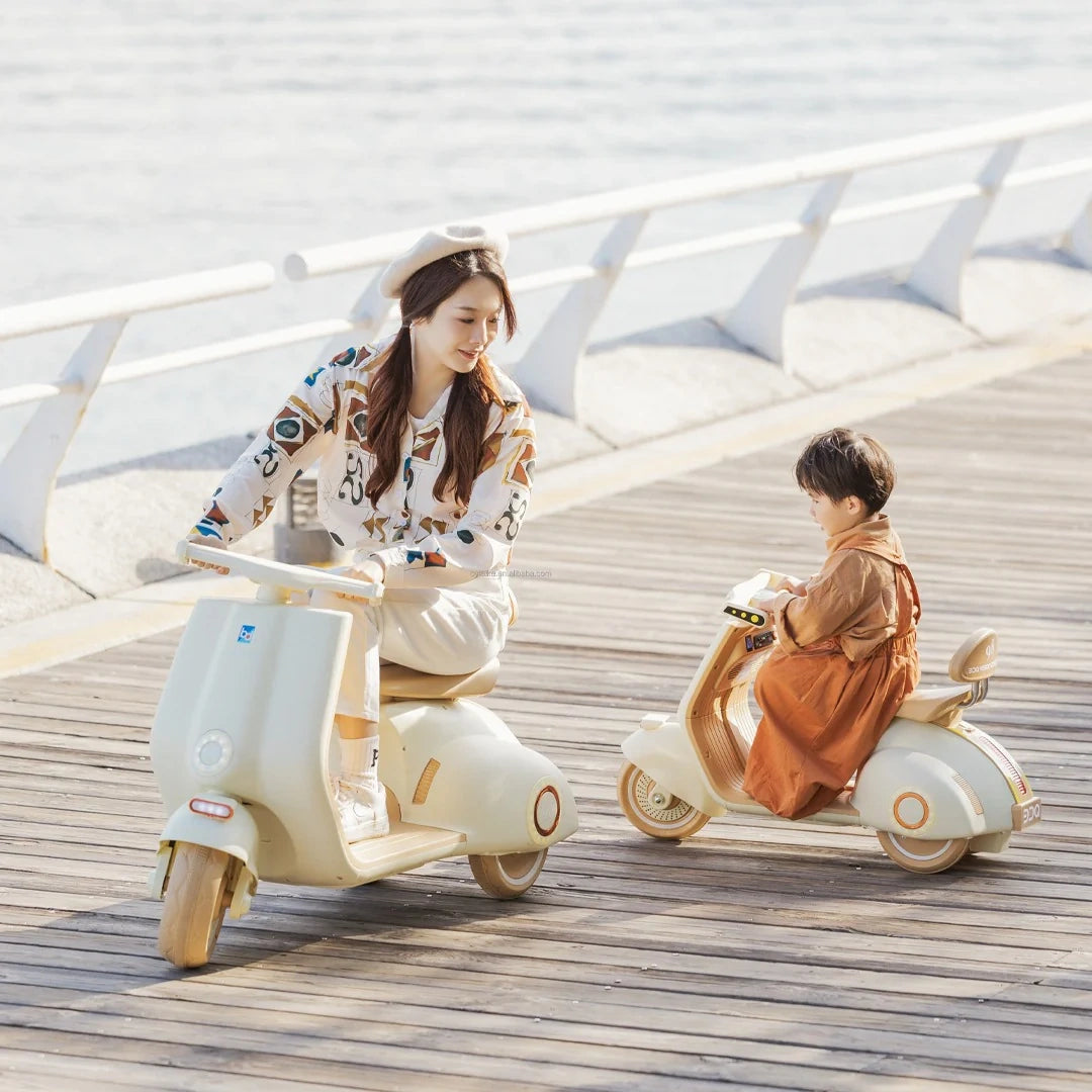 Two children on small scooters on a wooden deck with a modern architectural background