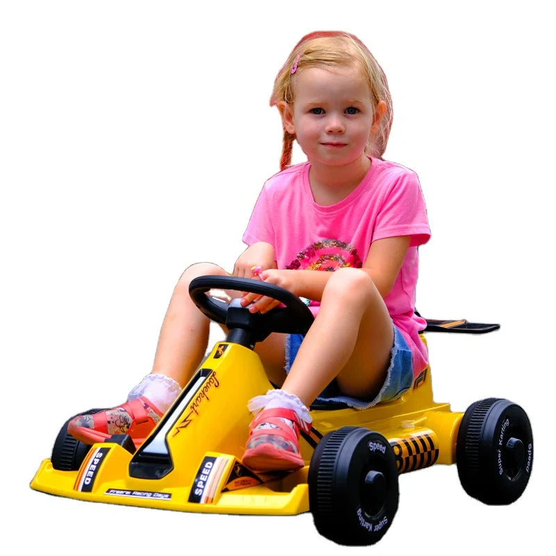 Child sitting in a yellow toy go-kart on a white background