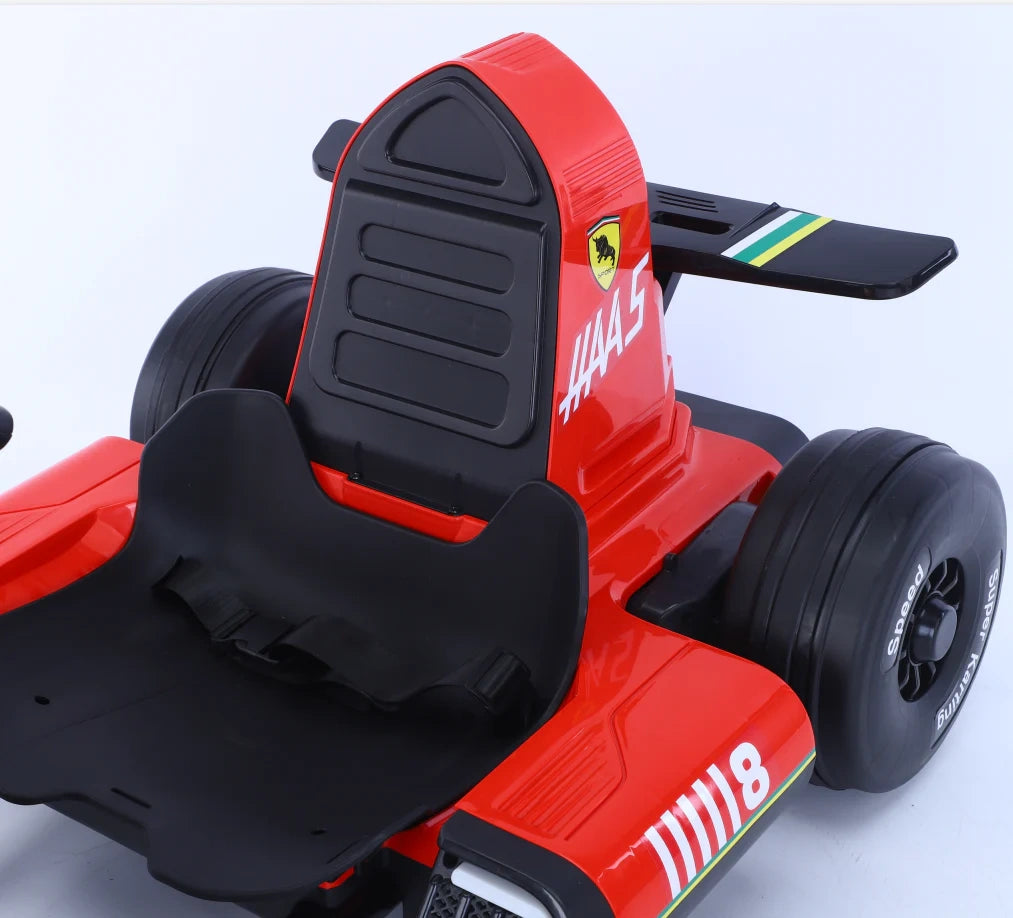 Red toy Formula 1 car with black seat on a light gray background