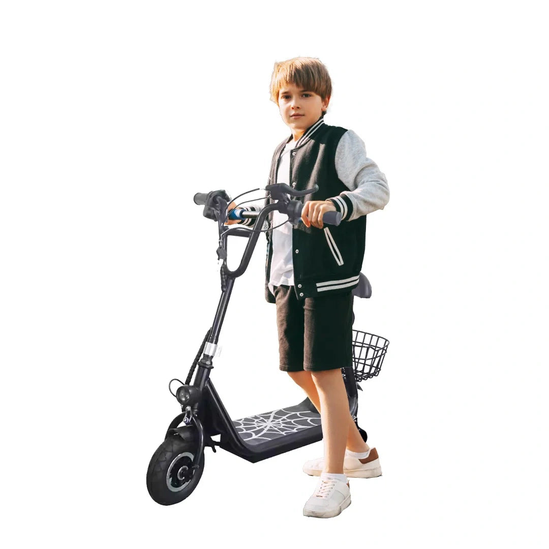 Child standing next to a black scooter on a white background