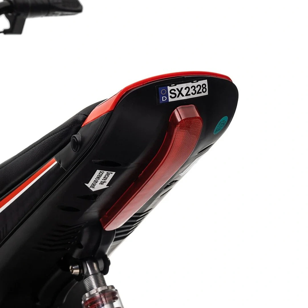 Close-up of a black and red scooter with visible model number on a white background