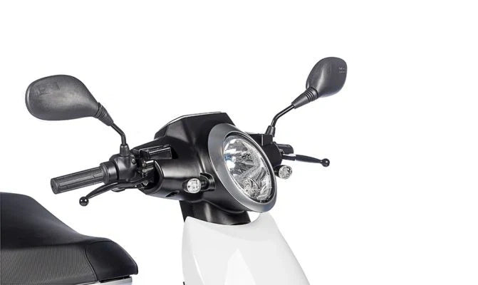 Close-up of a motorcycle handlebar with headlight and mirrors on a white background