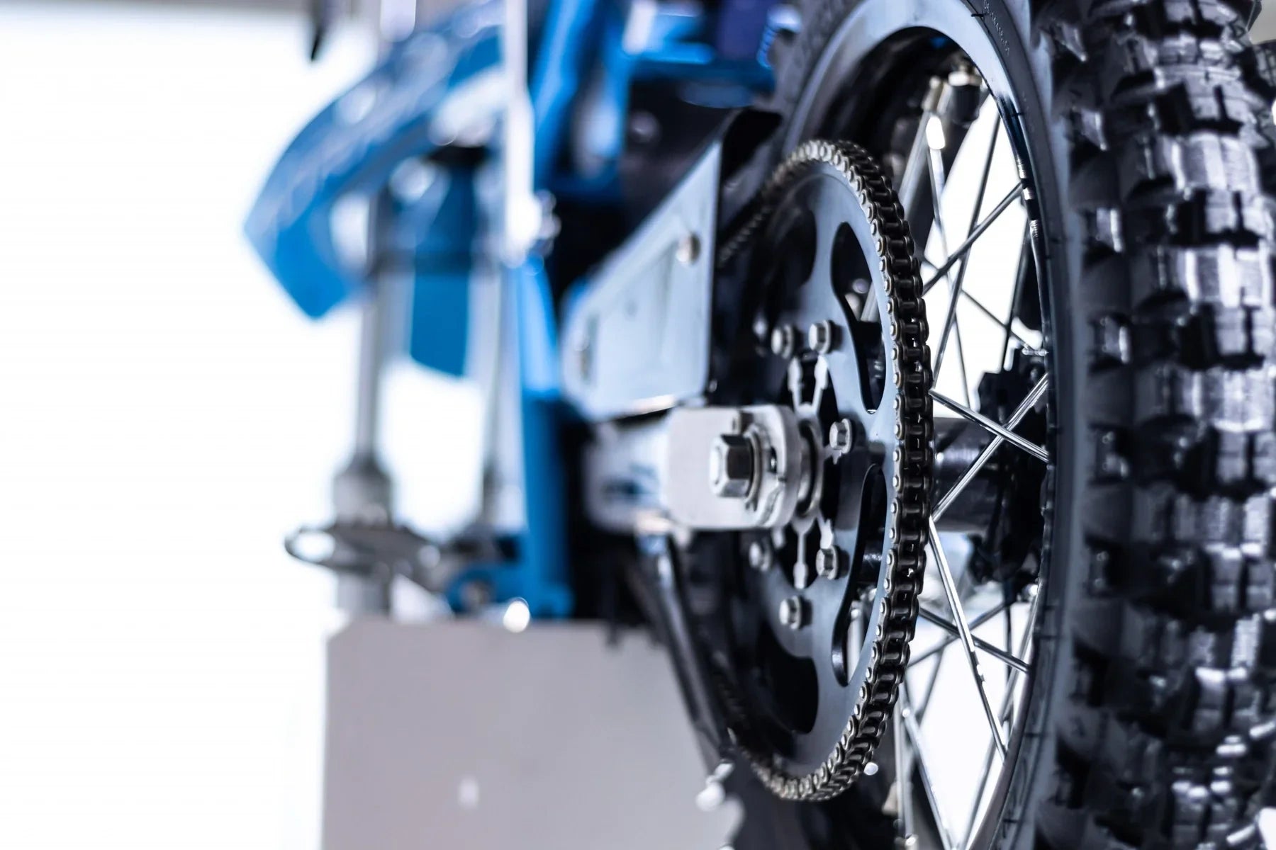 Close-up of a motorcycle chain and sprocket on a blurred background