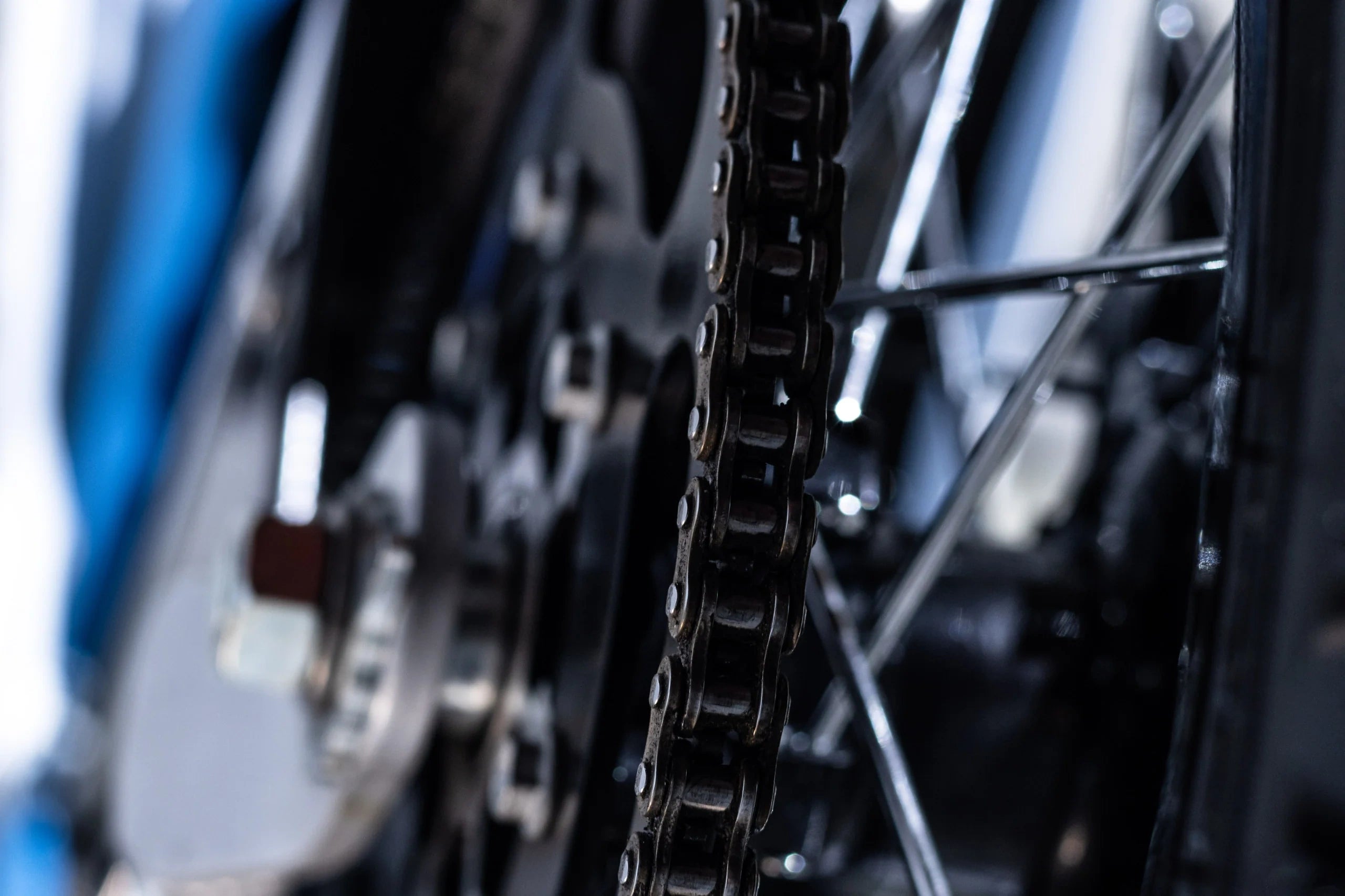 Close-up of a motorcycle chain and sprocket with blurred background