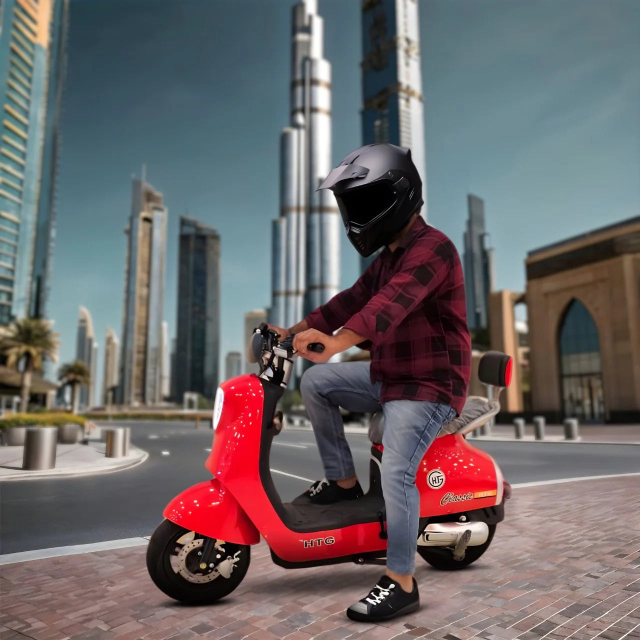 Person riding a red scooter in an urban setting with tall buildings in the background
