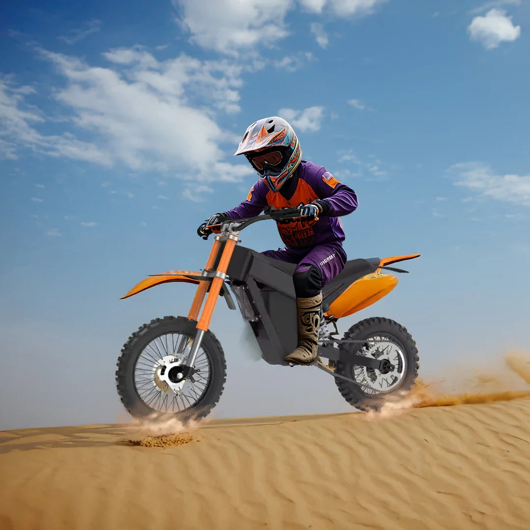 Person riding an orange dirt bike on sand dunes with a clear blue sky.