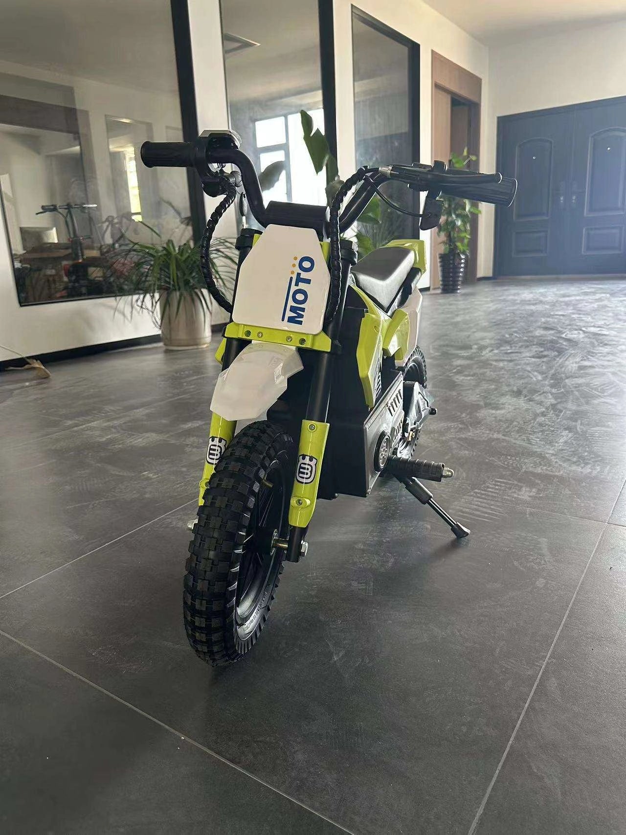 Small off-road vehicle with 'Moto' branding on a tiled floor.