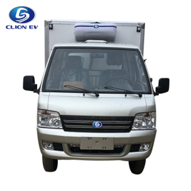 ocean cartz head-on studio shot of a silver electric refrigerated truck against a white background. This electric commercial vehicle shows the cab and the mounted white and blue refrigeration unit on top of the large cargo box. The image features the front grille, headlights, and mirrors of this specialized refrigerator delivery van for cold chain logistics.