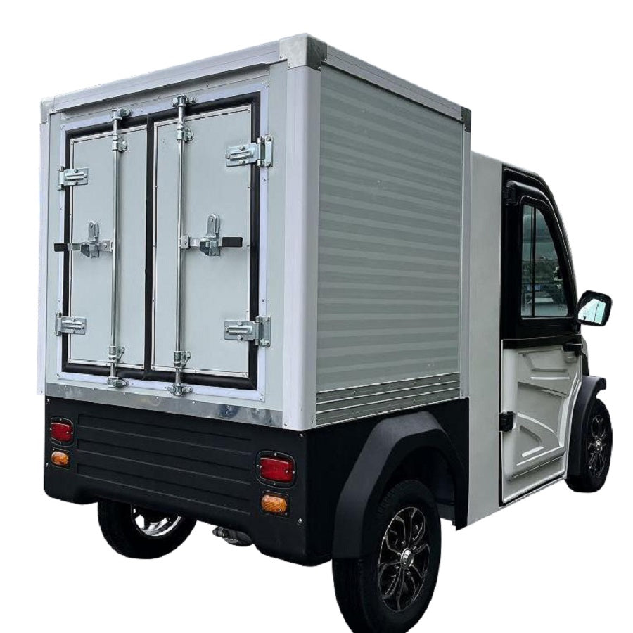 ocean cartz rear three-quarter studio shot of a white electric refrigerated delivery vehicle with an enclosed cab, set against a white background. This compact electric NEV or refrigerator work cart features a silver insulated rear cargo box with double doors and a black lower bumper. The vehicle has black fender flares and black custom wheels, highlighting its use for cold chain last-mile delivery.