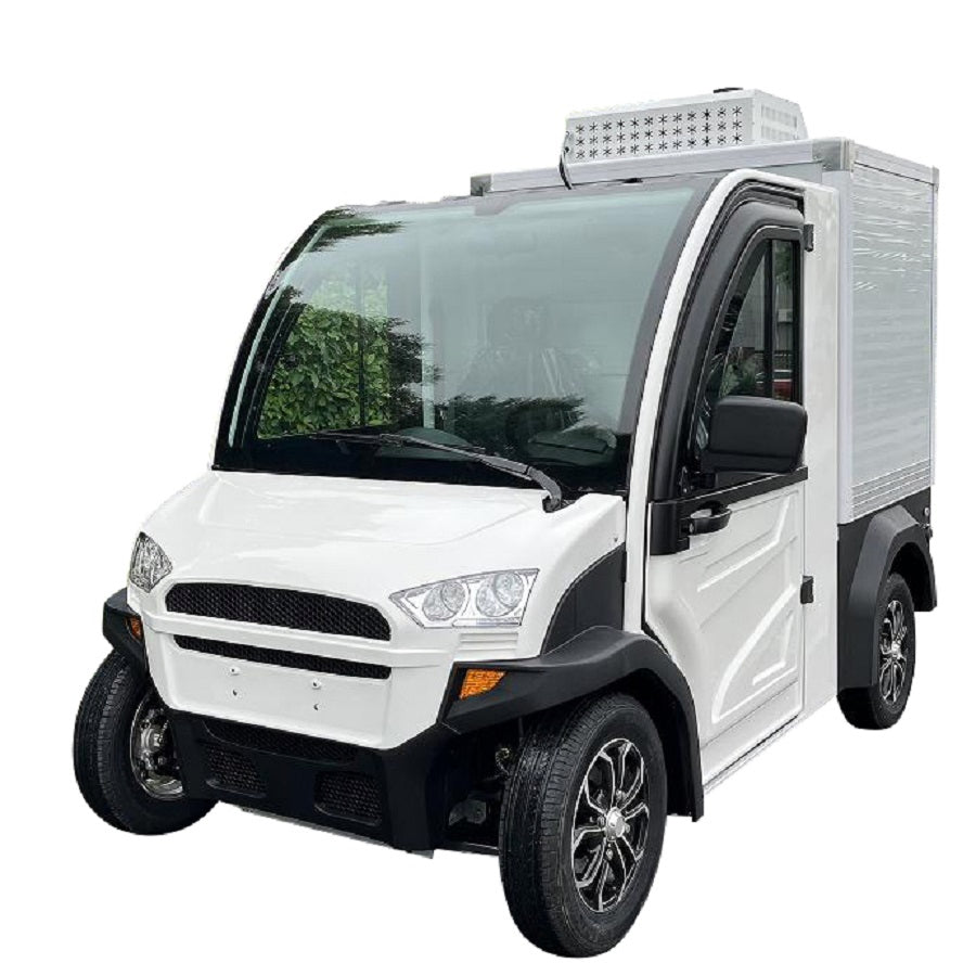 ocean cartz three-quarter front studio shot of a white electric refrigerated delivery vehicle with an enclosed cab and an insulated rear cargo box, set against a white background. This compact electric NEV or refrigerator work cart features a black roof, black trim, and a white refrigeration unit visible on top of the cargo box. The vehicle is equipped with custom black and silver wheels, highlighting its function for cold chain last-mile delivery.