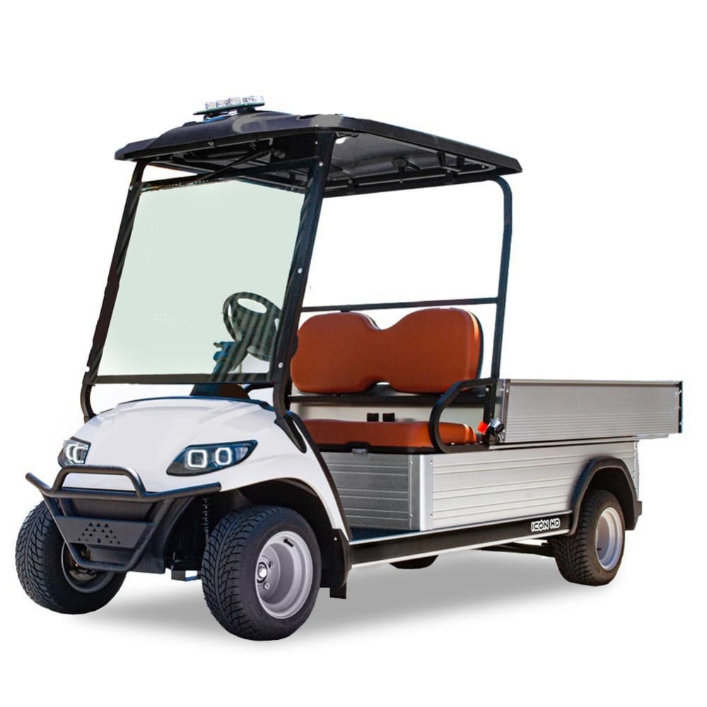 ocean cartz three-quarter front studio shot of a white utility electric vehicle with a flat, silver aluminum cargo bed, set against a pure white background. This specialized electric work cart features a black roof, a black front brush guard, and brown two-seater upholstery. The utility golf cart has a wide windshield, all-terrain tires, and silver wheels, emphasizing its heavy-duty hauling capabilities.