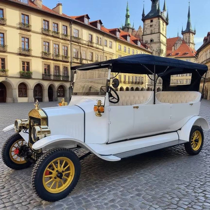 Vintage white car with gold accents on a cobblestone street in a historic town square.