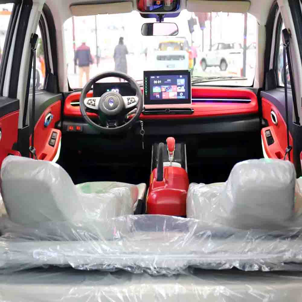 Car interior with a laptop on the dashboard, wrapped seats, and plastic covering.