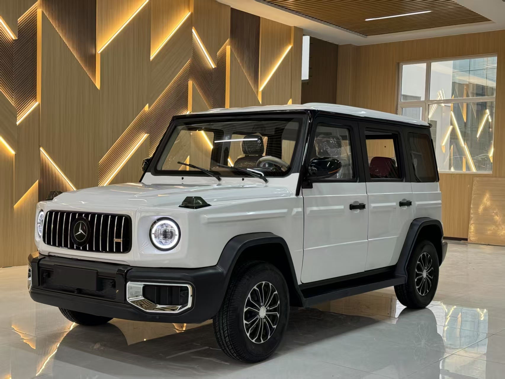 White Mercedes-Benz G-Class SUV in a showroom with geometric wall design