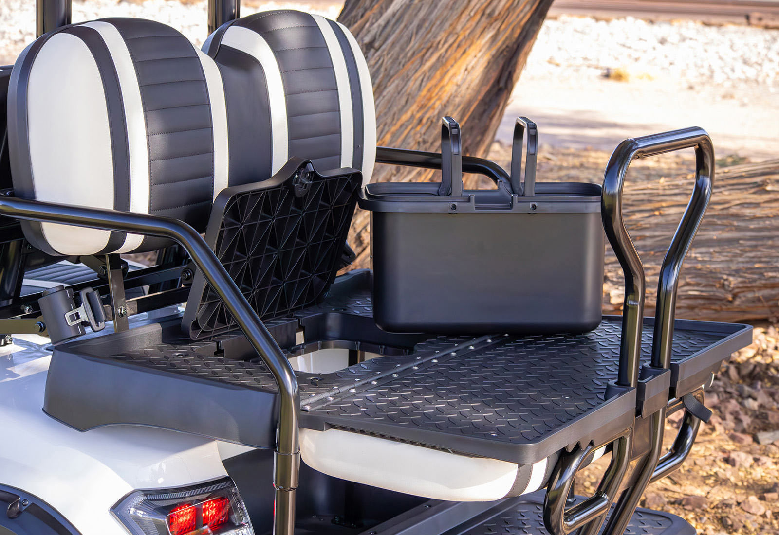 Black storage box on a golf cart with striped seats in the background