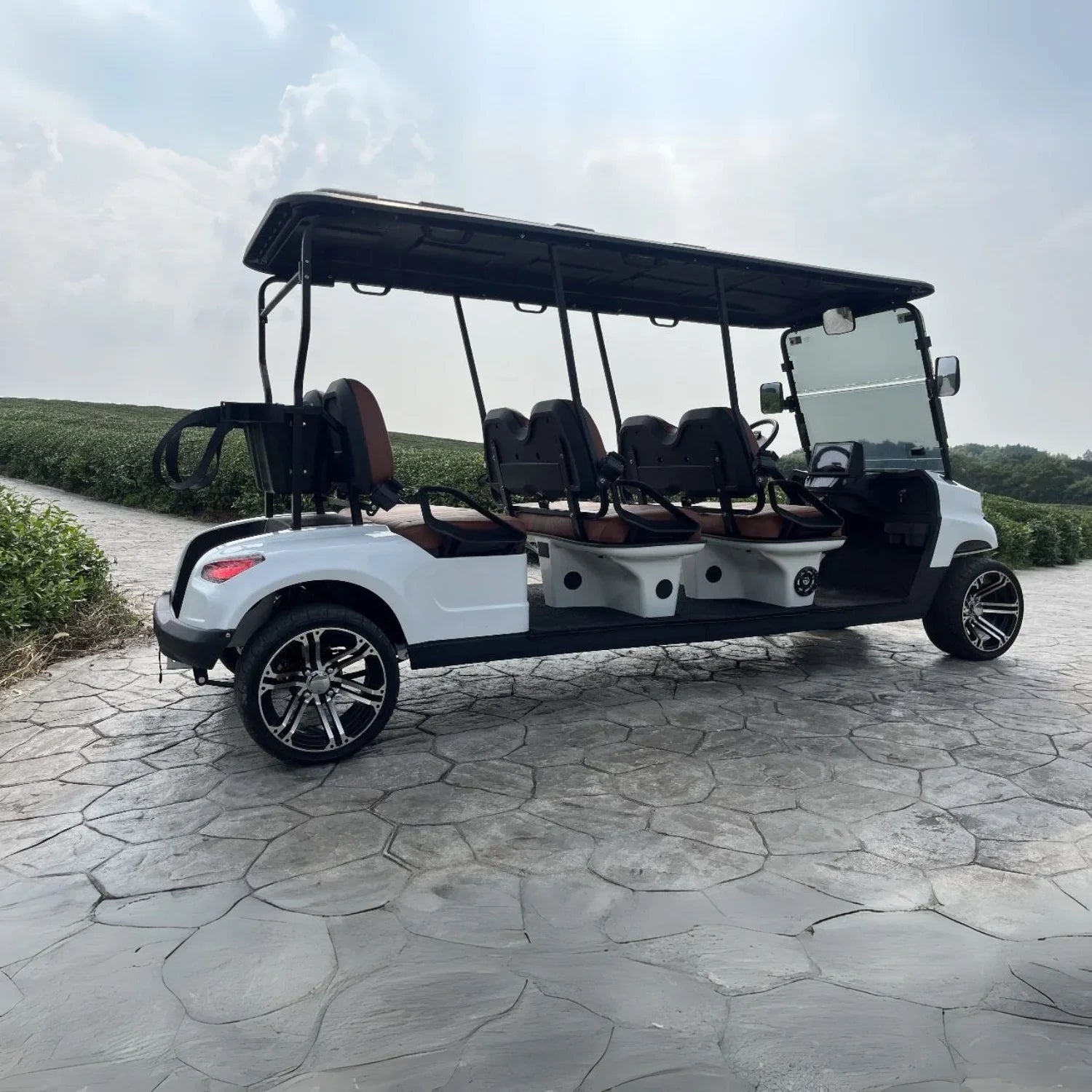 White golf cart with brown seats on a stone path