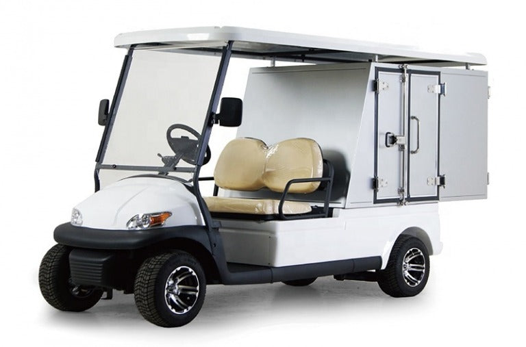 ocean cartz three-quarter front studio shot of a white two-seater utility golf cart with a white roof, set against a pure white background. This specialized electric work cart features tan seats and a rear compartment with two enclosed white storage cabinets with black handles. The service vehicle is equipped with all-terrain tires and custom black and silver wheels, highlighting its use for maintenance or delivery tasks.