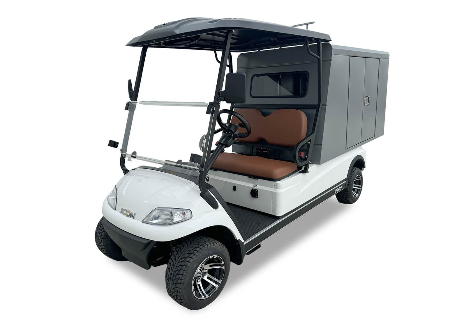 ocean cartz three-quarter front studio shot of a white two-seater utility golf cart with a black roof, set against a pure white background. This specialized electric work cart features a large, enclosed grey rear storage cabinet with black doors and a small window, designed for secure maintenance and delivery tasks. The cab area has brown seats and a folding windshield. The electric service vehicle is equipped with all-terrain tires and custom black and chrome wheels.