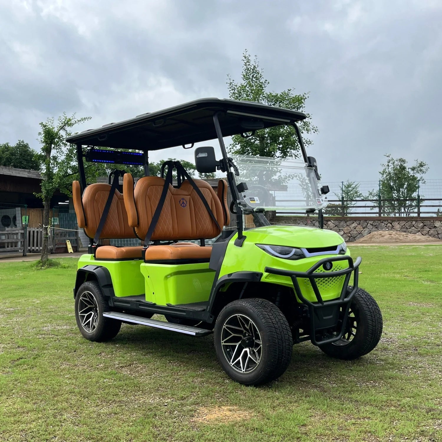 Lime green golf cart with brown seats on a grassy area