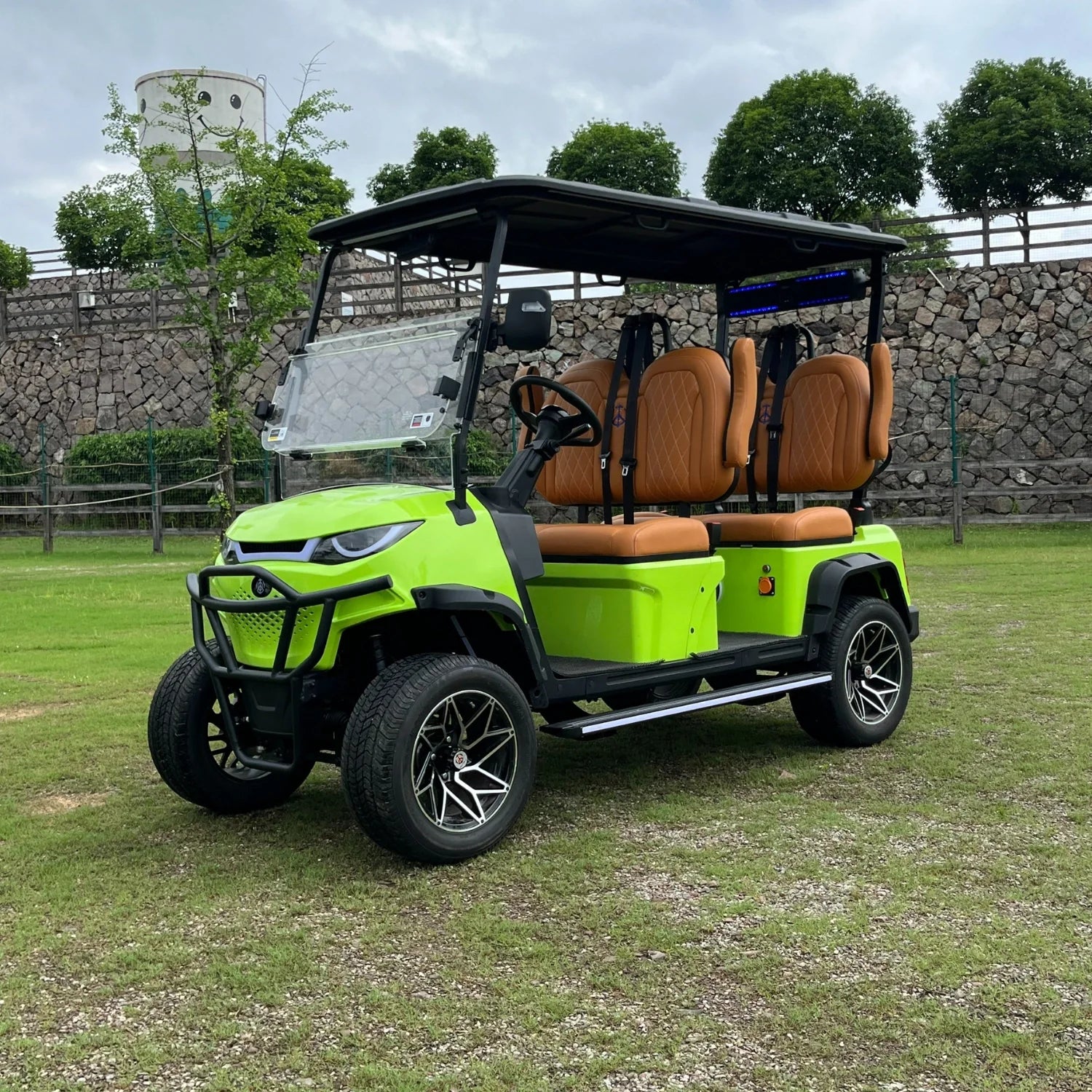 Green golf cart with brown seats on a grassy area