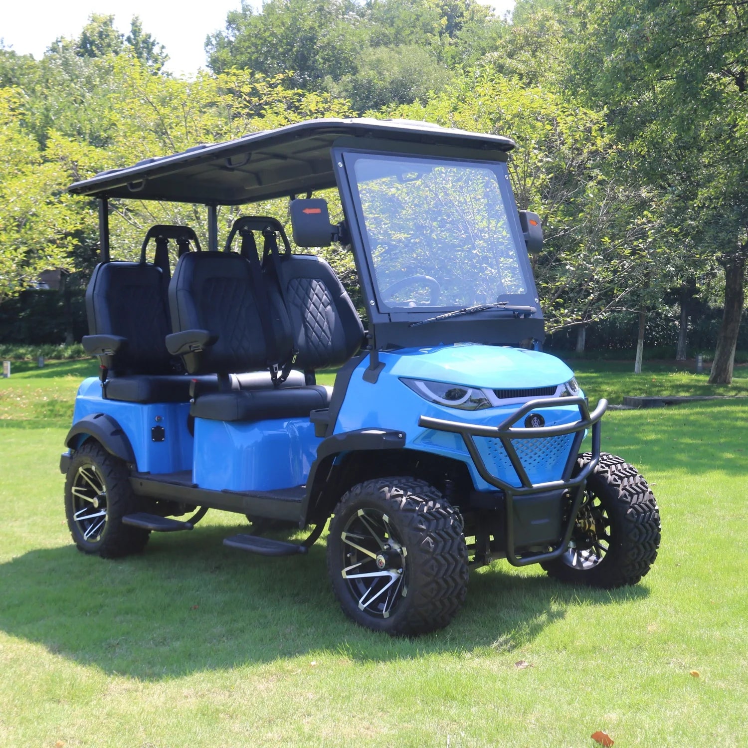Blue golf cart on a grassy area with trees in the background