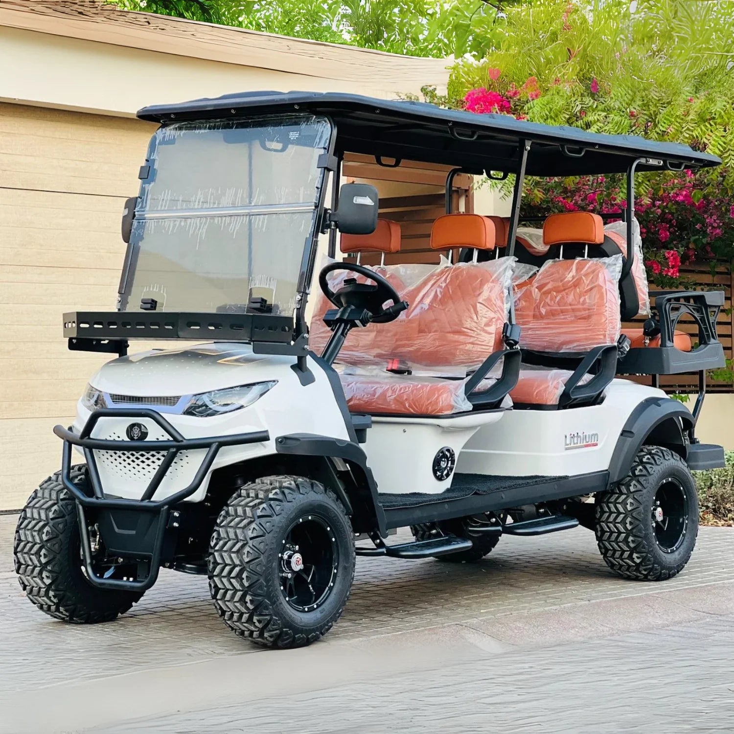 White golf cart with orange seats on a wooden deck