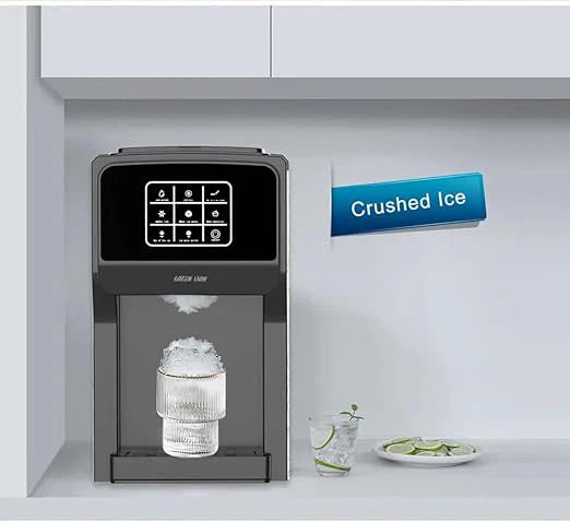 Ice machine dispensing crushed ice with a glass of water and lime slices on a white countertop.