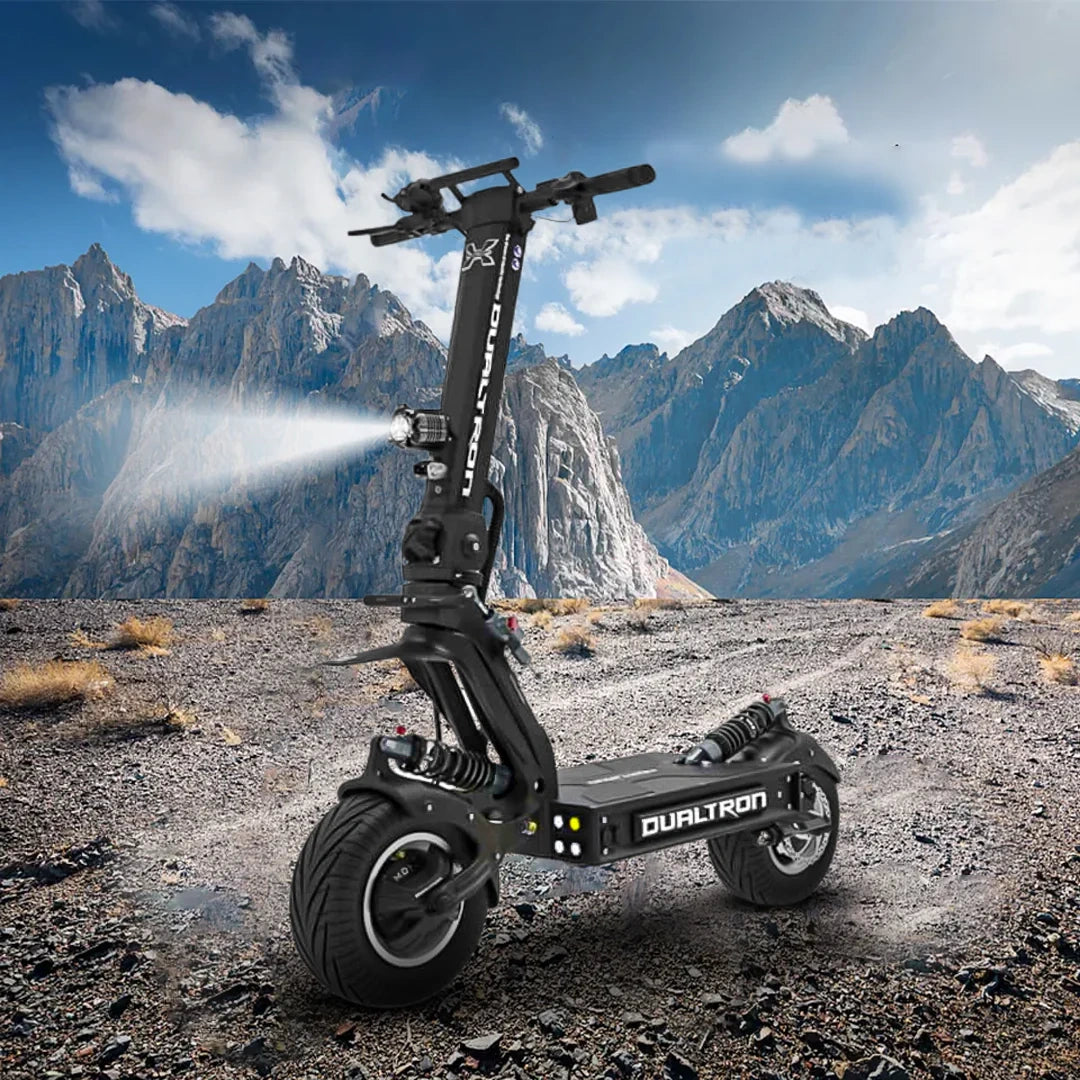 Dualtron electric scooter on a mountainous landscape with snow-capped peaks.