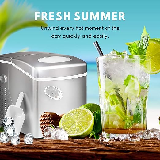 Portable ice maker with a glass of iced drink and lime slices on a wooden surface.